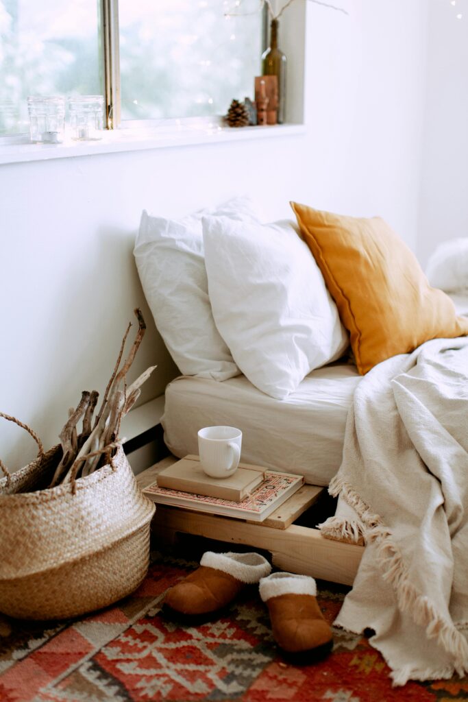 pexels-photo-3933278-3933278 A cozy bedroom setup featuring pillows, a blanket, and warm-toned decor.